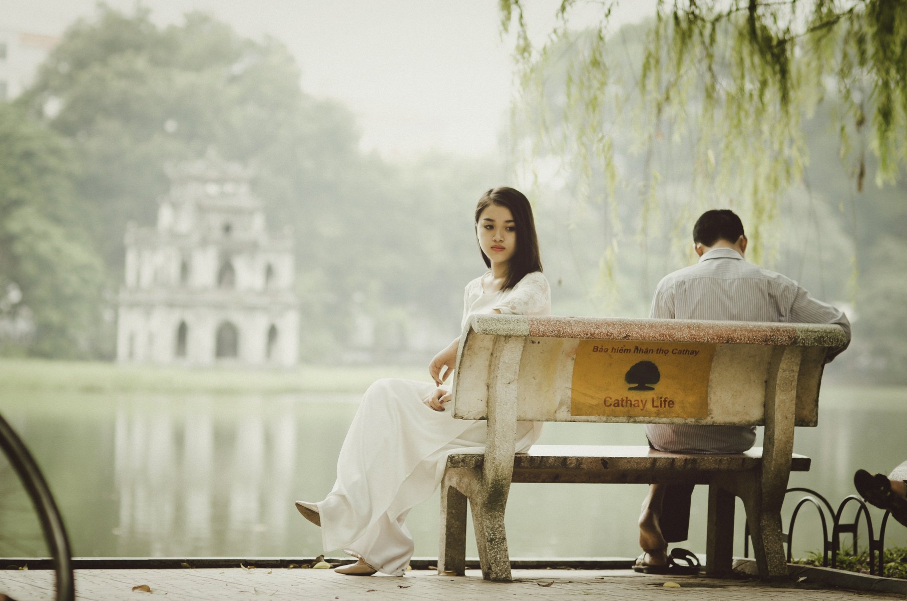 Casal sentado separadamente em banco no parque